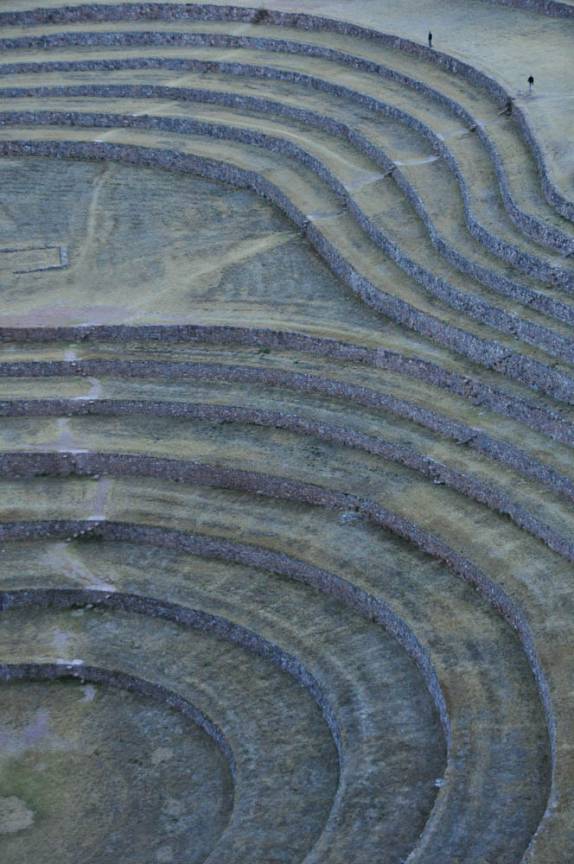 Minúsculos, o Rodrigo e o Gustavo caminham ao lado dos terraços agrícolas de Moray, do tempo dos incas, no Valle Sagrado, perto de Cusco, no Peru